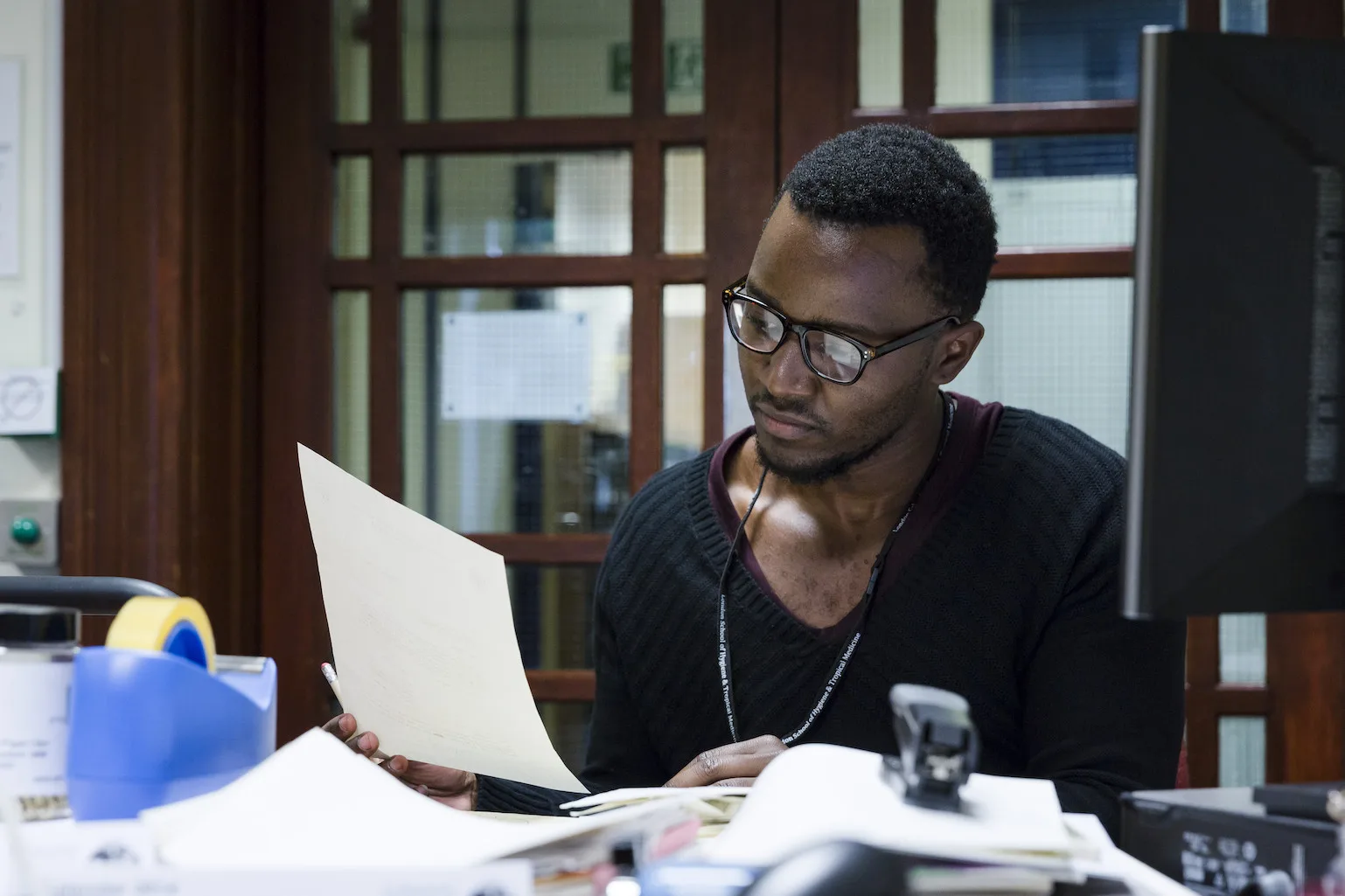 Researcher reviewing enclomiphene documents at desk.